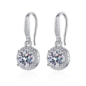 Macro shot of silver halo drop earrings with large round center stone and diamond border