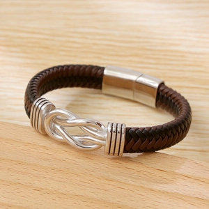 Handmade brown braided leather punk bracelet with a silver magnetic clasp on wood