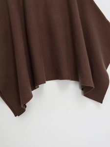 Detail of dark coffee knit fabric texture with draped asymmetrical hemline on white background