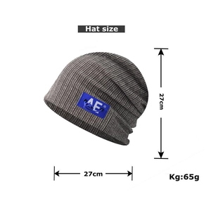 Detailed view of dark grey striped knit beanie with AE logo label and dimensions