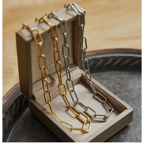 Close-up of thick geometric rectangle link chains in gold and silver finish
