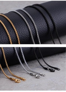 Close-up of stainless steel necklace chains in gold, silver, and black with lobster clasps