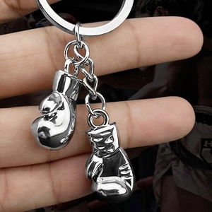 Polished silver metal boxing glove keychain pair held in hand with high-shine finish