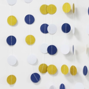 Detailed view of hanging gold, dark blue, and white glitter paper circle garland strands