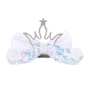 Detail of white sequined bow hair clip with a sparkling rhinestone crown for girls