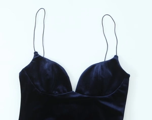 Detail view of deep blue velvet texture on a slim strap V-neck bodysuit top