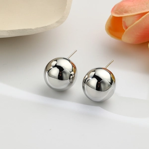 Macro shot of silver sphere stud earrings with a polished mirror finish on white background