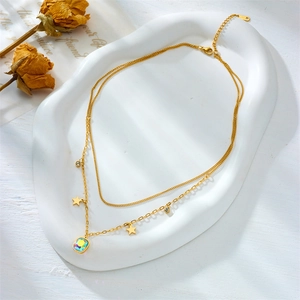 Close-up of golden double-layer necklace with star charms and oval iridescent stone