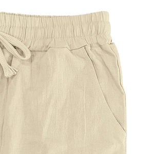 Détail du pantalon en lin beige avec taille élastique et cordon de serrage tressé
