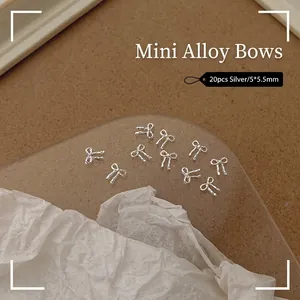 Detailed view of 20pcs silver mini alloy bowknot nail art charms on vintage background