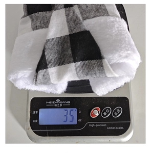 Detail shot showing a 35g lightweight black and white plaid Christmas hat on a digital scale