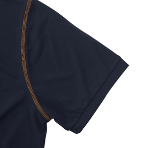 Vue macro d'un haut de sport bleu marine avec coutures orange et texture en maille filet