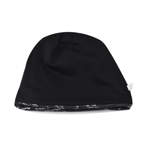 Close-up of black knitted beanie featuring printed lining and white wash care label