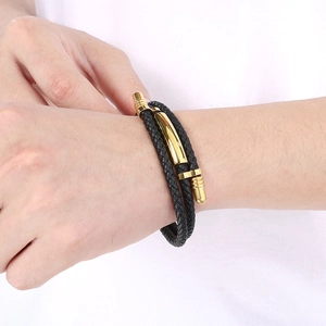 Detail of multi-layer woven black and gold leather bracelet on a male wrist