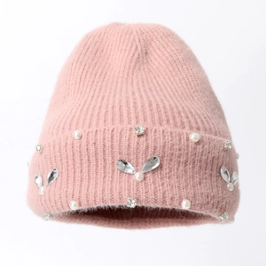 Primo piano di un berretto in maglia rosa con strass a forma di coniglio e perle
