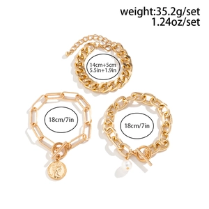 Detailed view of three-piece gold chain bracelet set with pearl and coin charms