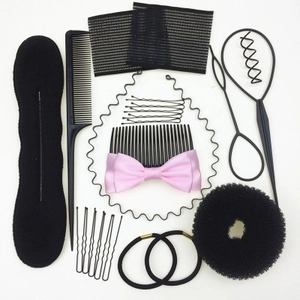 Complete black hair styling kit including bun makers, combs and pink bow hairpins on white
