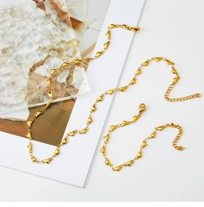 Detail view of 18K gold-plated heart link chain necklace and bracelet with lobster clasp