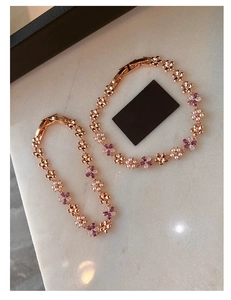 Macro detail of rose gold flower bracelets with purple zircons and white pearls