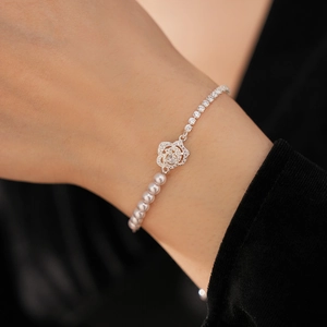 Detailed shot of camellia flower bracelet with white pearls and sparkling cubic zirconia
