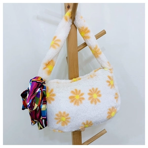 Detail of white plush shoulder bag with yellow daisy prints and a colorful silk scarf