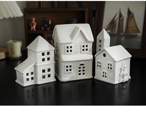 Close-up of white ceramic Christmas light houses with warm glowing windows