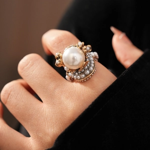 Detailed close-up of a vintage pearl flower ring with a large center pearl and gold base