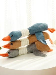 Detailed texture of colorful plush duck dog toys in blue, brown, and grey woven fabric