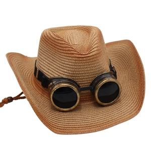 Détail du chapeau de cowboy en paille avec lunettes vintage bronze et sangle de style ethnique