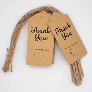 Close-up of brown kraft paper thank you tags with heart cutout and twine strings