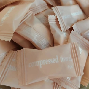 Close-up of disposable compressed towels in light pink individual portable packaging