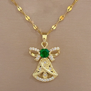 Macro view of gold angel pendant with emerald green stone and sparkling crystals