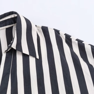 Close-up of lapel and shoulder stitching on a classic black and white striped shirt