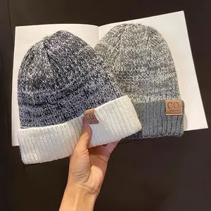 Winter fleece-lined knit beanies in mixed black-white and grey-white with leather logo