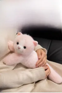 Close-up of soft pink and white long-hair plush Persian cat doll being held by person