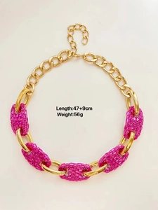 Detail of chunky pink rhinestone encrusted link necklace with gold-tone chain for party wear.