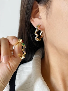Detail view of gold geometric earrings featuring colorful rectangular cubic zirconia stones