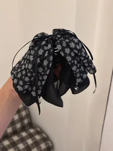 Detail of black chiffon bow hair claw clip with rose floral print and delicate bead charms