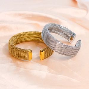 Detail of gold and silver mesh woven bracelets on soft champagne silk background