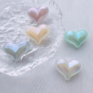 Macro shot of colorful iridescent heart beads with holes for DIY jewelry making
