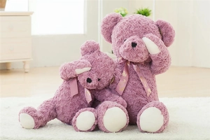 Detail of two purple teddy bears in rose swirl plush fabric with floral bows