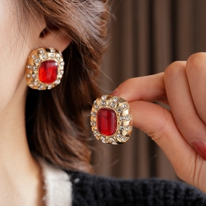 Details von Vintage-Goldohrringen mit rotem Harzstein und funkelndem Kristallkranz