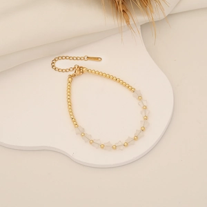 Detail of beaded star bracelet with golden beads and transparent star-shaped charms