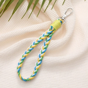 Close-up of multicolor braided lanyard with silver spring buckle on beige fabric background