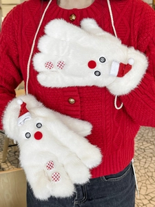 Detail of white plush Christmas snowman gloves with hanging rope on red sweater