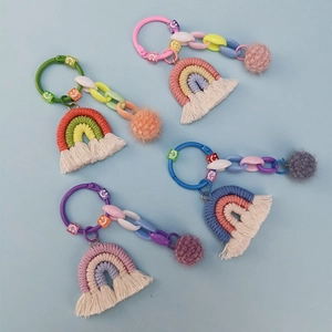 Macro detail of handmade rainbow keychain with cotton weaving, tassel, and colorful beads