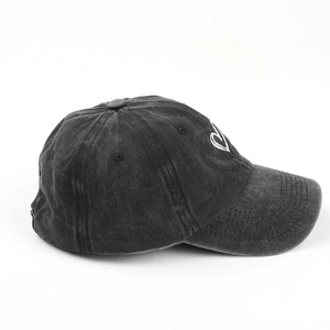 Close-up of heart embroidery and washed denim texture on a vintage baseball cap