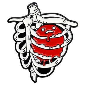 Detailed close-up of cartoon enamel pin featuring white rib cage and sad red heart
