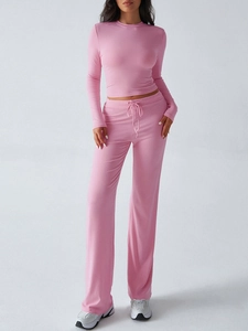Pink Y2K style slim long sleeve top and high-waisted drawstring trousers set on model