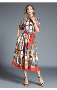 Detail of short sleeve vintage print dress featuring retro stripes and a red waist tie belt